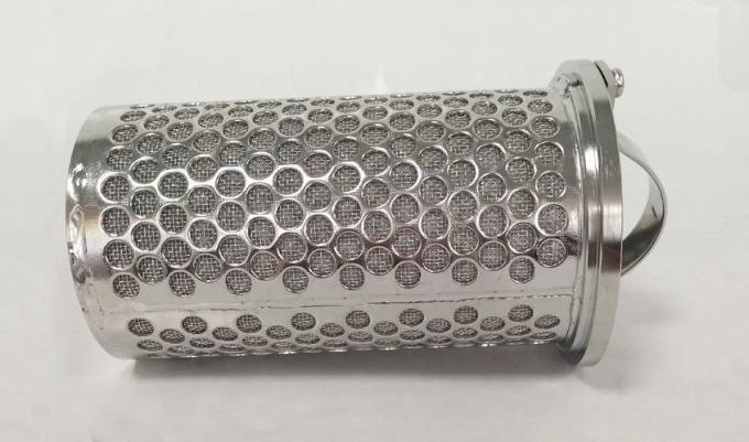 Пефорированная спеченная металлом корзина фильтра лежит на серой предпосылке.